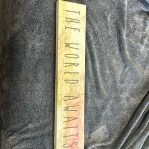 Sign for a bedroom “The world Awaits”